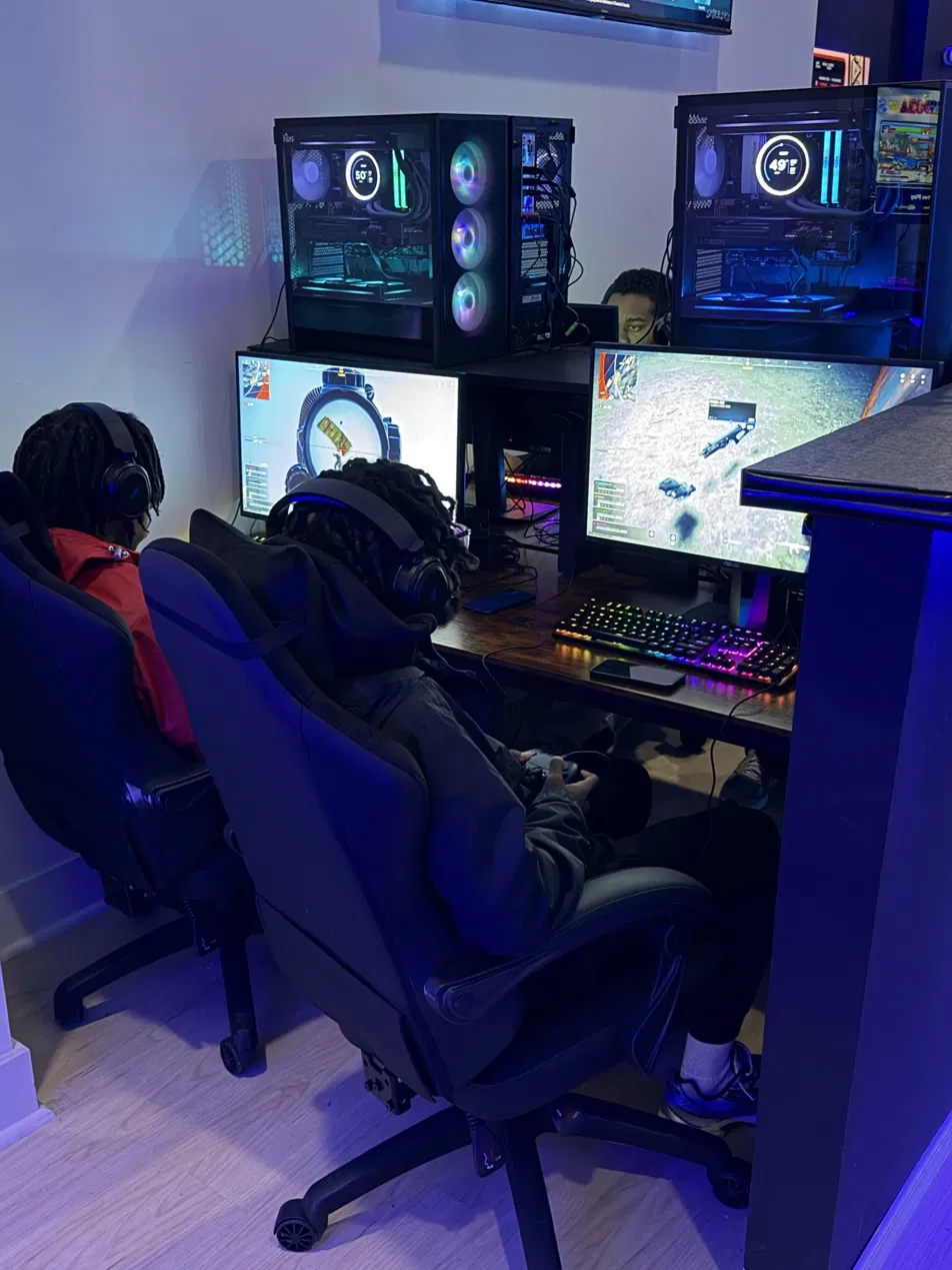 Youth in session at Open World Gaming Center, seated at gaming stations with headsets